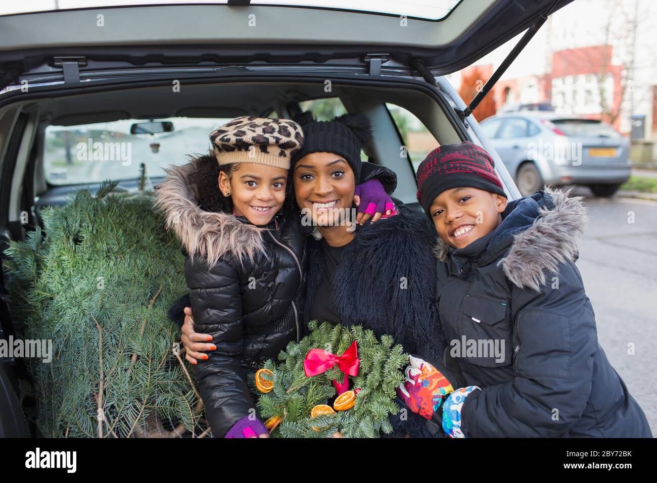 Portrait bonne mère et enfants avec arbre de Noël et couronne Banque D'Images