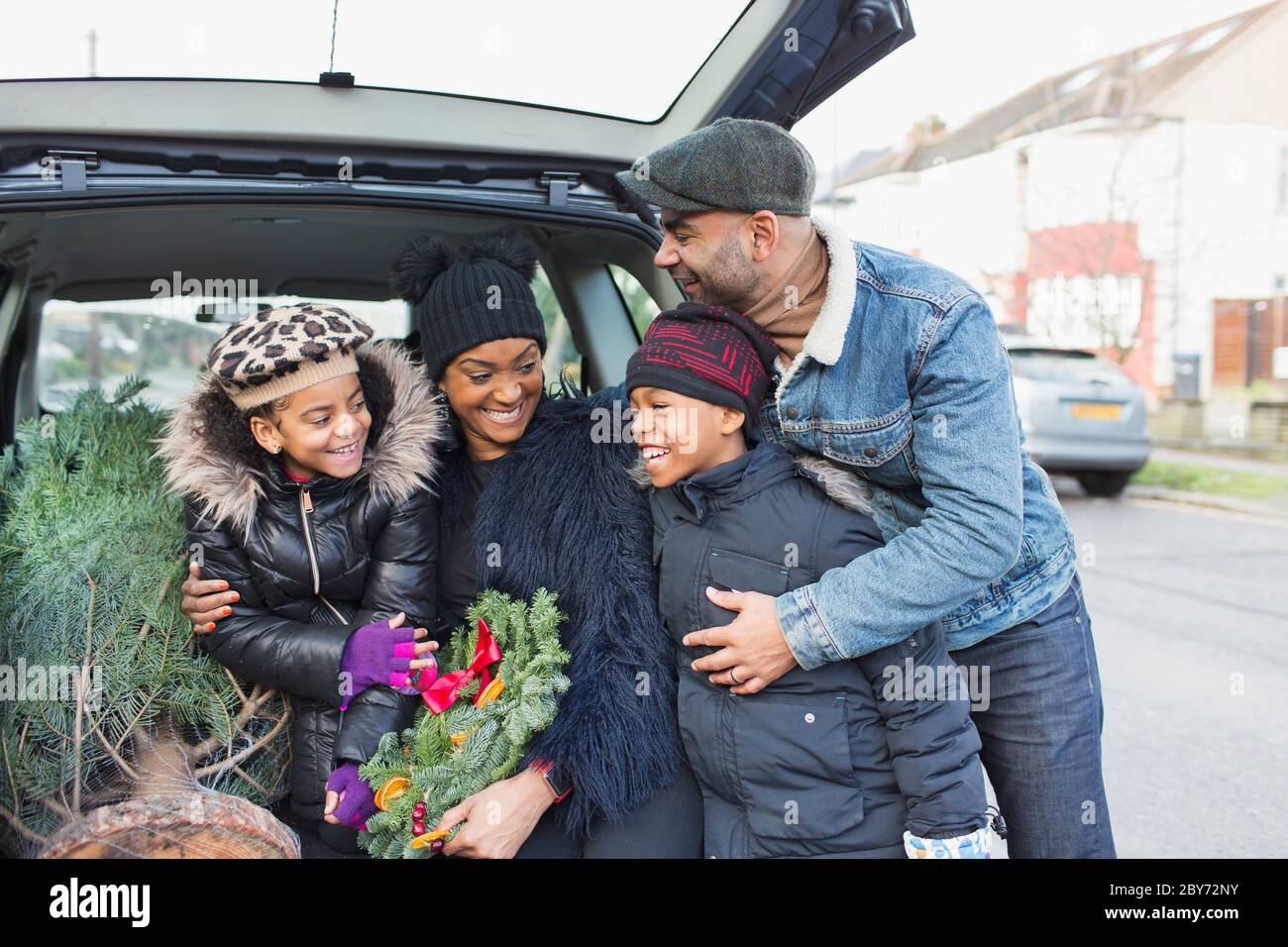 Famille heureuse avec arbre de Noël en voiture Banque D'Images