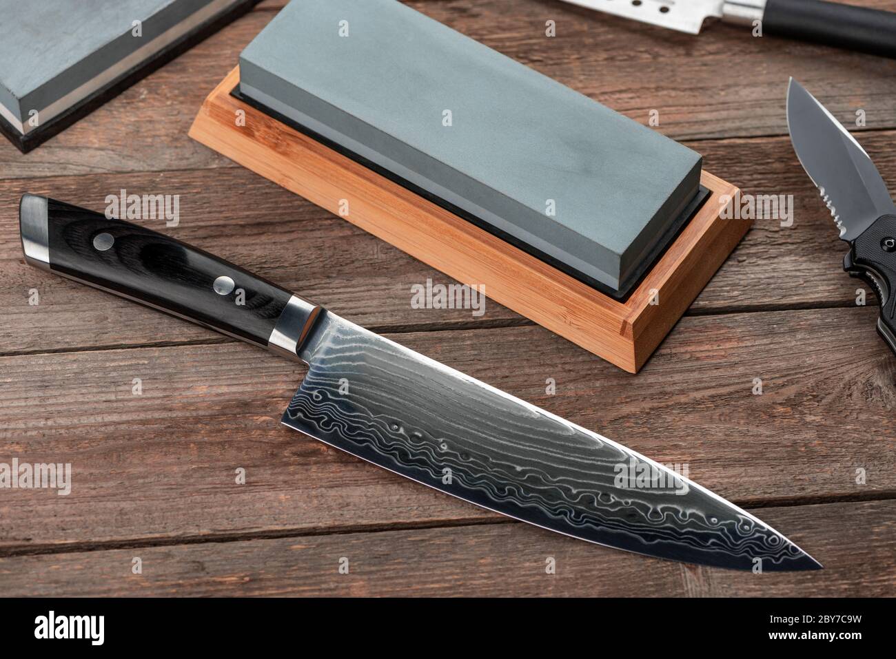 Vue de dessus sur un couteau japonais Gyuto, un couteau à lame rétractable  et une pierre à affûter Photo Stock - Alamy