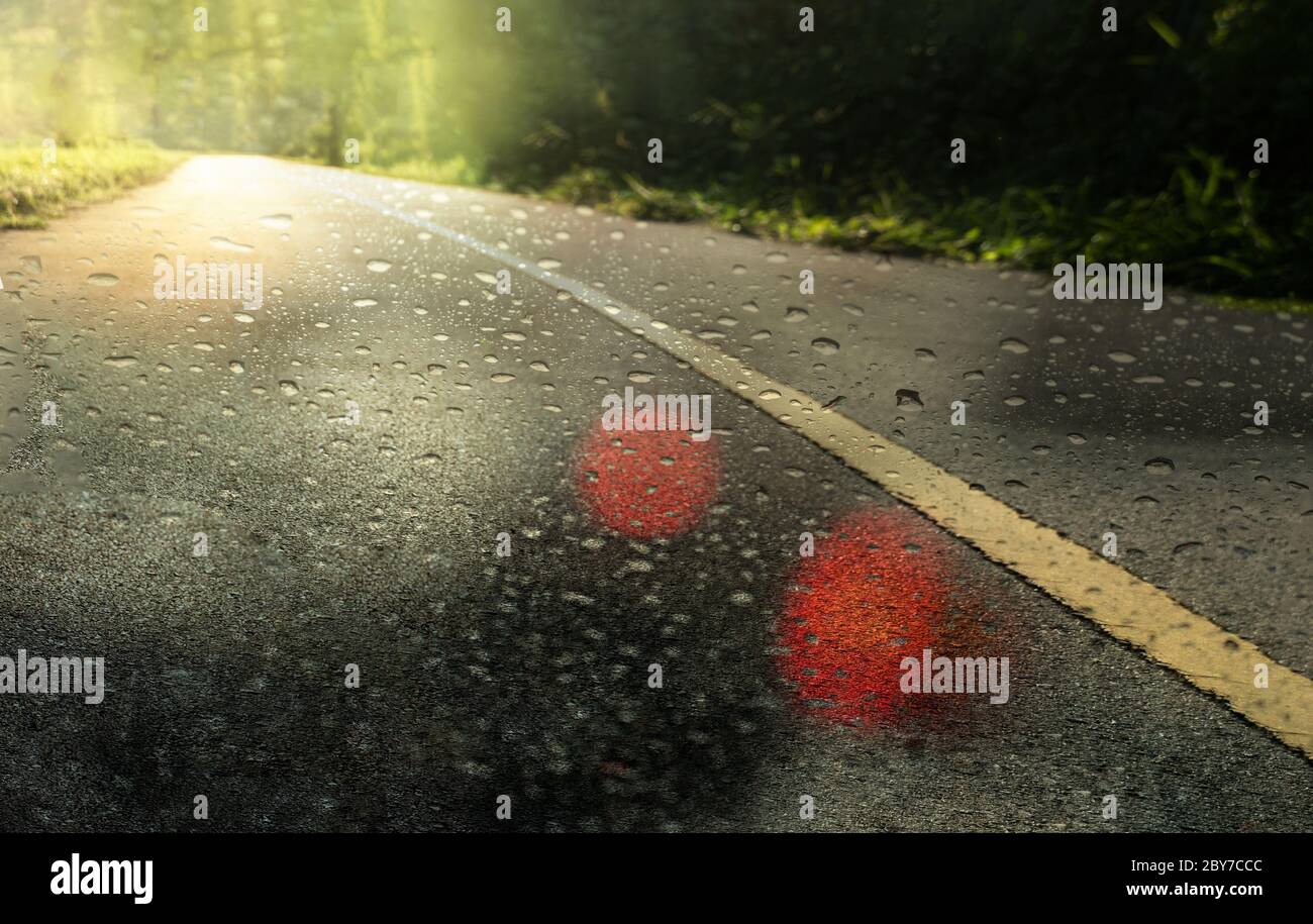 ville route ou rue en asphalte sombre dans la journée de pluie avec goutte d'eau et fond vert clair orange doux Banque D'Images