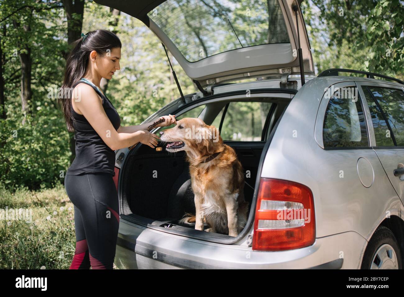 Fille debout à côté du chien dans le tronc Banque D'Images