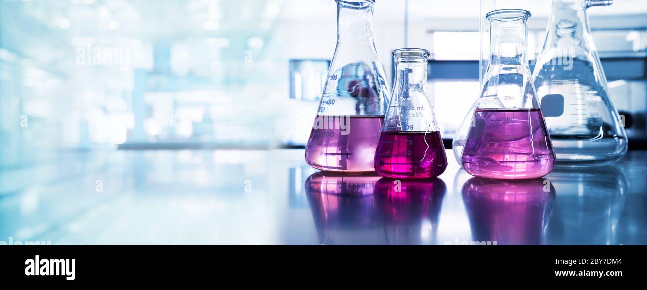 flacon en verre violet en lumière bleue recherche chimie science bannière laboratoire fond Banque D'Images