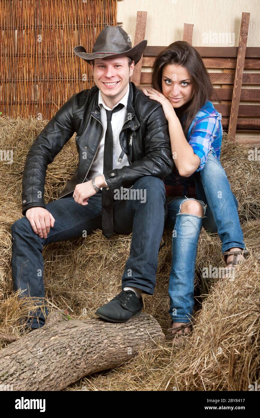 Jeunes cowboys de couple sur le foin Banque D'Images