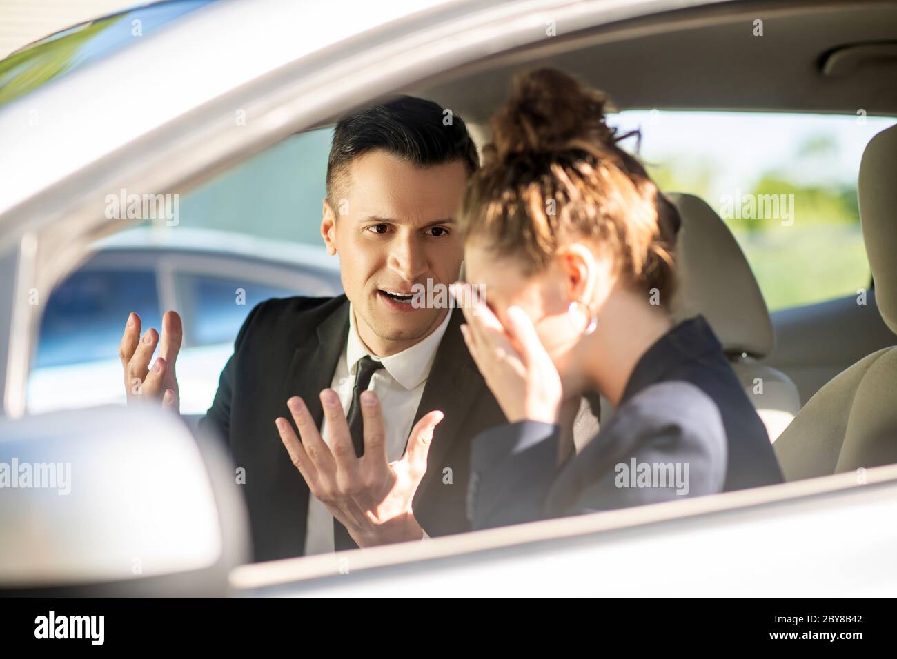 Homme d'affaires sérieux et femme qui pleure dans une voiture Banque D'Images