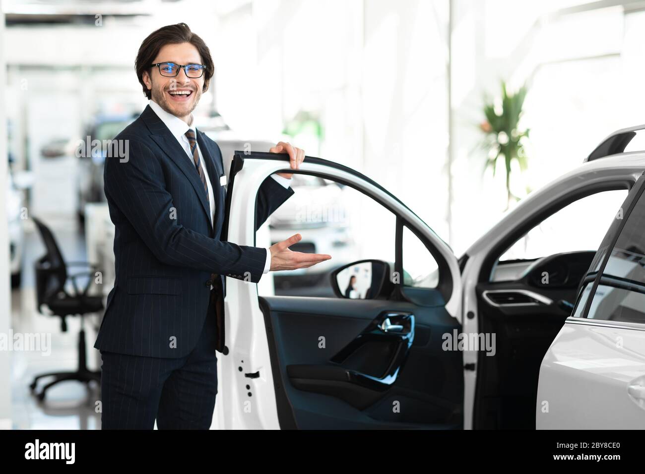 Concessionnaire présentant une nouvelle porte d'ouverture d'automobile pour le client Banque D'Images