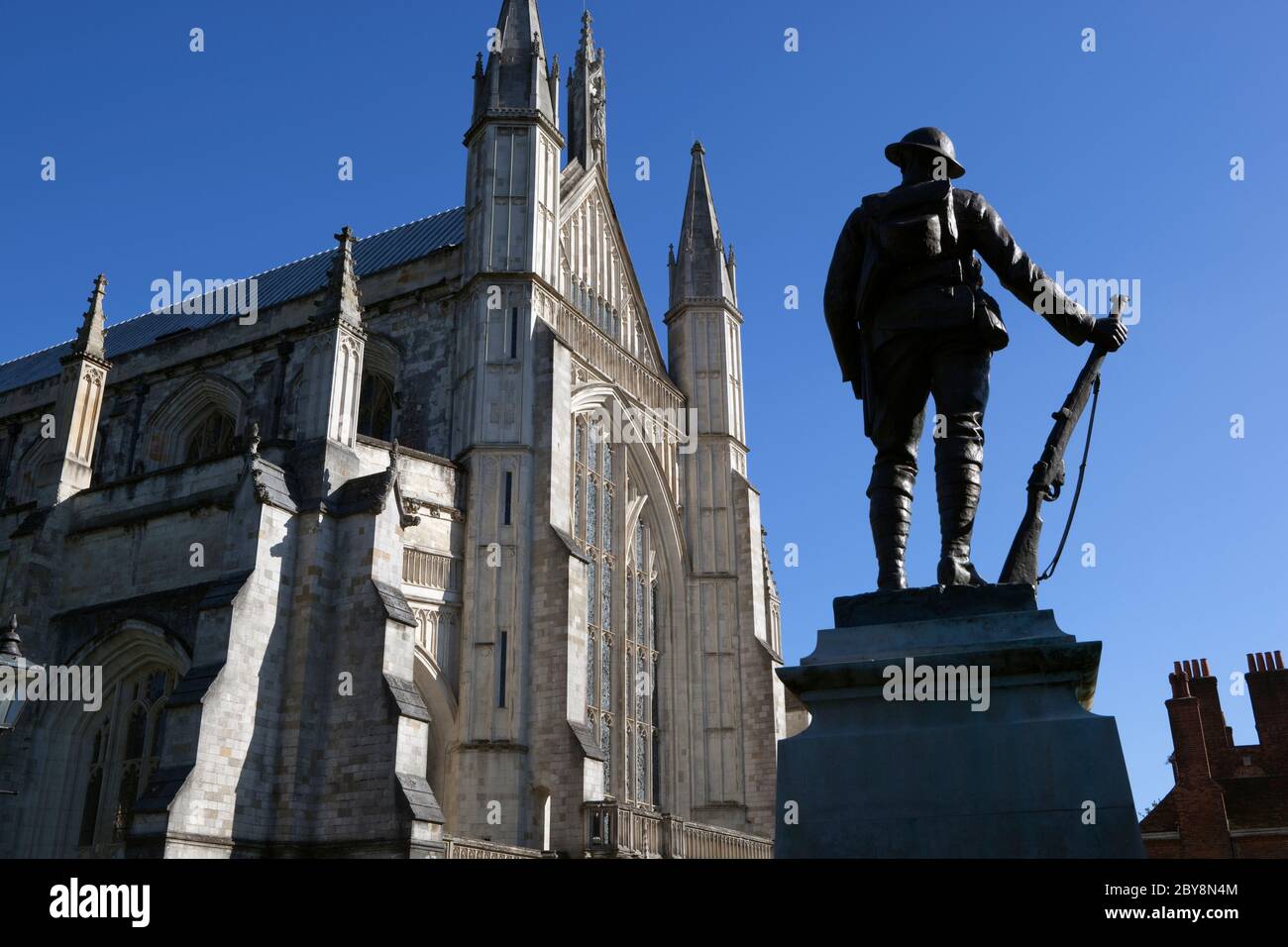 Statue du Soldat inconnu devant le front ouest de la cathédrale de Winchester, Winchester, Hampshire, Angleterre, Royaume-Uni Banque D'Images