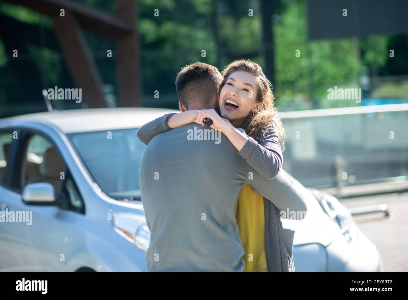 Une femme incroyablement joyeuse qui embrasse l'homme dans la rue. Banque D'Images