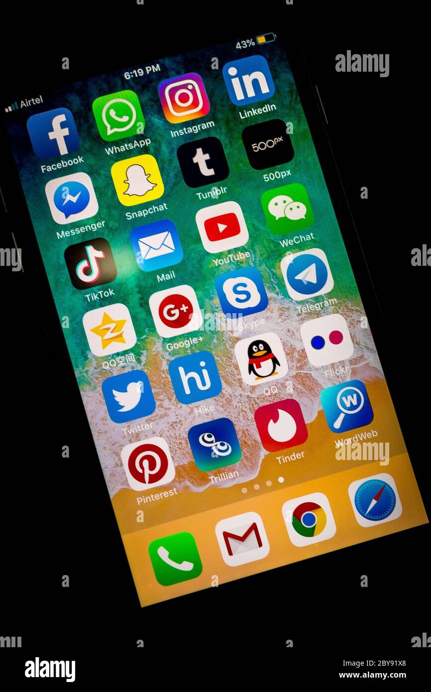 Un ensemble de programmes de marques célèbres de réseautage social sur un iPhone sur table en bois. IPhone argent a été créé et développé par Apple inc Banque D'Images
