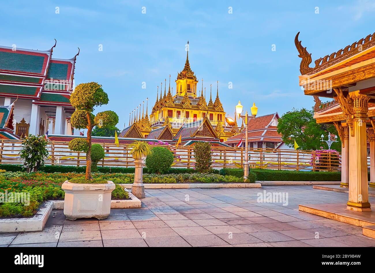 Les lumières tamisées décorent le bâtiment pittoresque du temple Loha Prasat du complexe Wat Ratchanatdaram, vu du parc topiaire Mahajetsadabadin, Bangkok, Banque D'Images