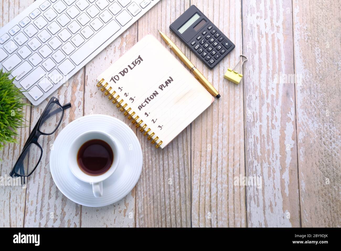 Tasse à café et carnet avec liste des tâches sur une table en bois Banque D'Images