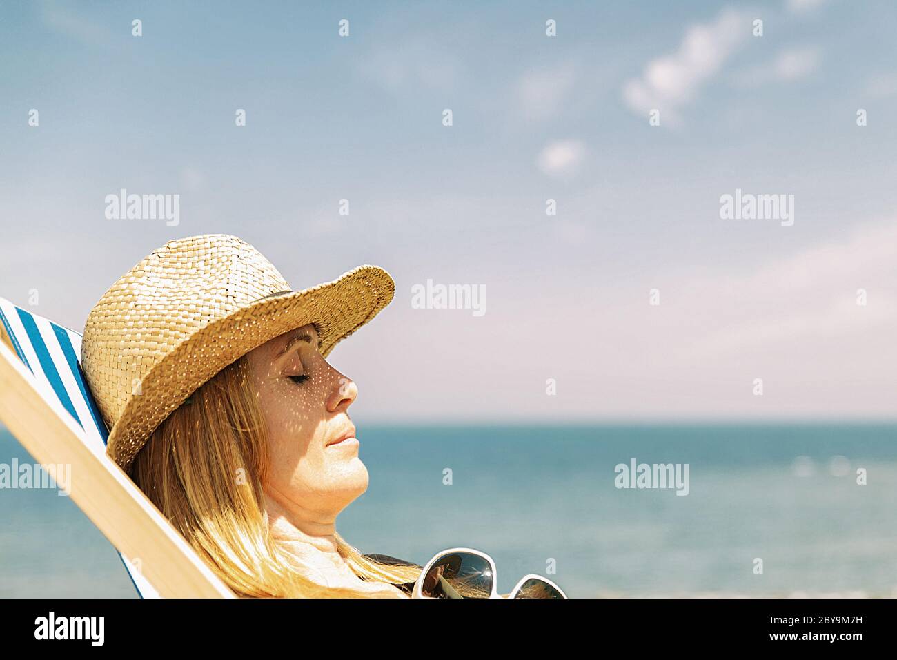 femme reposant sur un transat au soleil, sur la côte française Banque D'Images