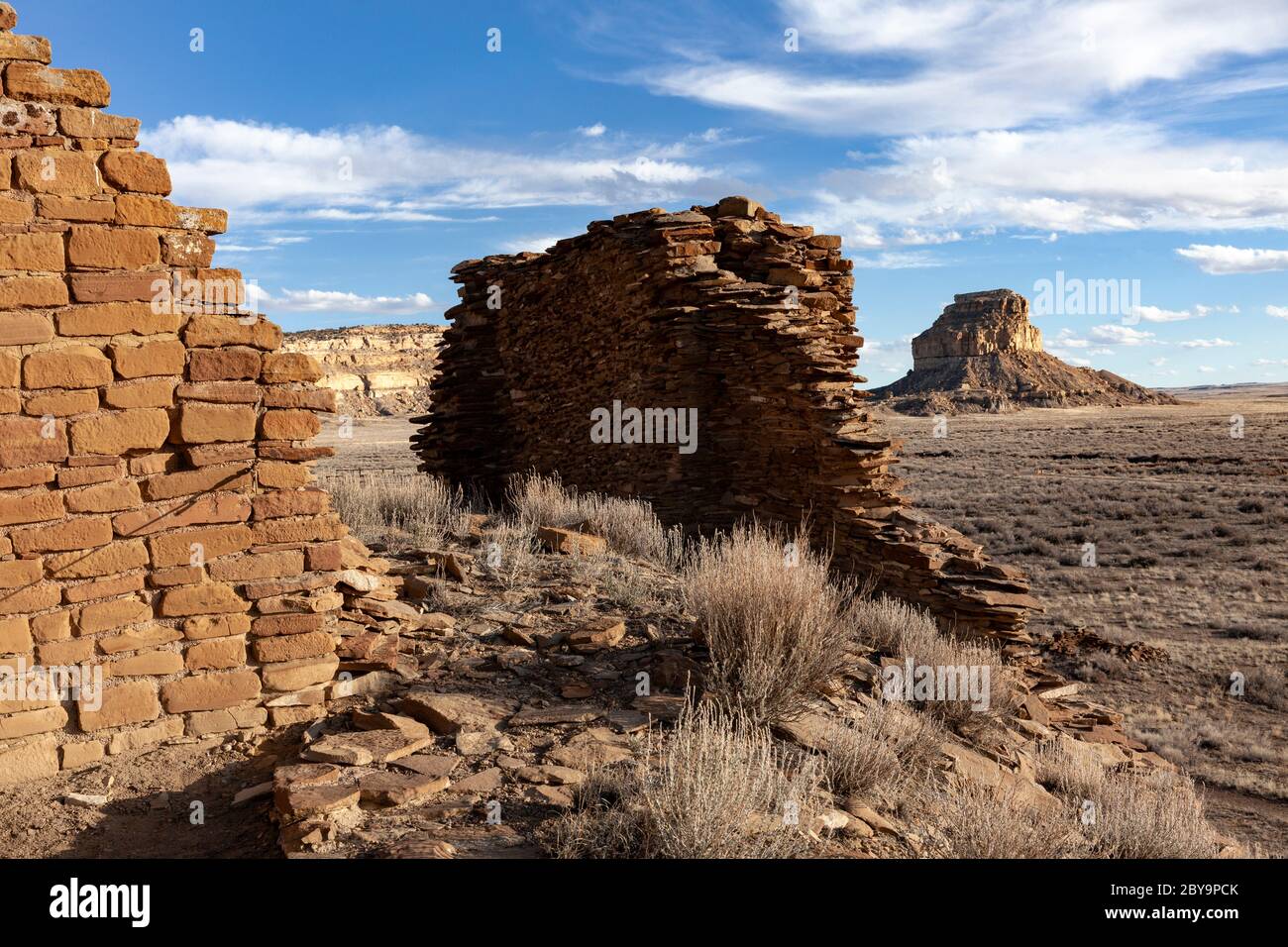 NM00580-00...NOUVEAU MEXIQUE - murs de maçonnerie en pierre construits par les premiers Chaco et Fajada Butte au loin. Parc national historique de Chaco Culture. Banque D'Images