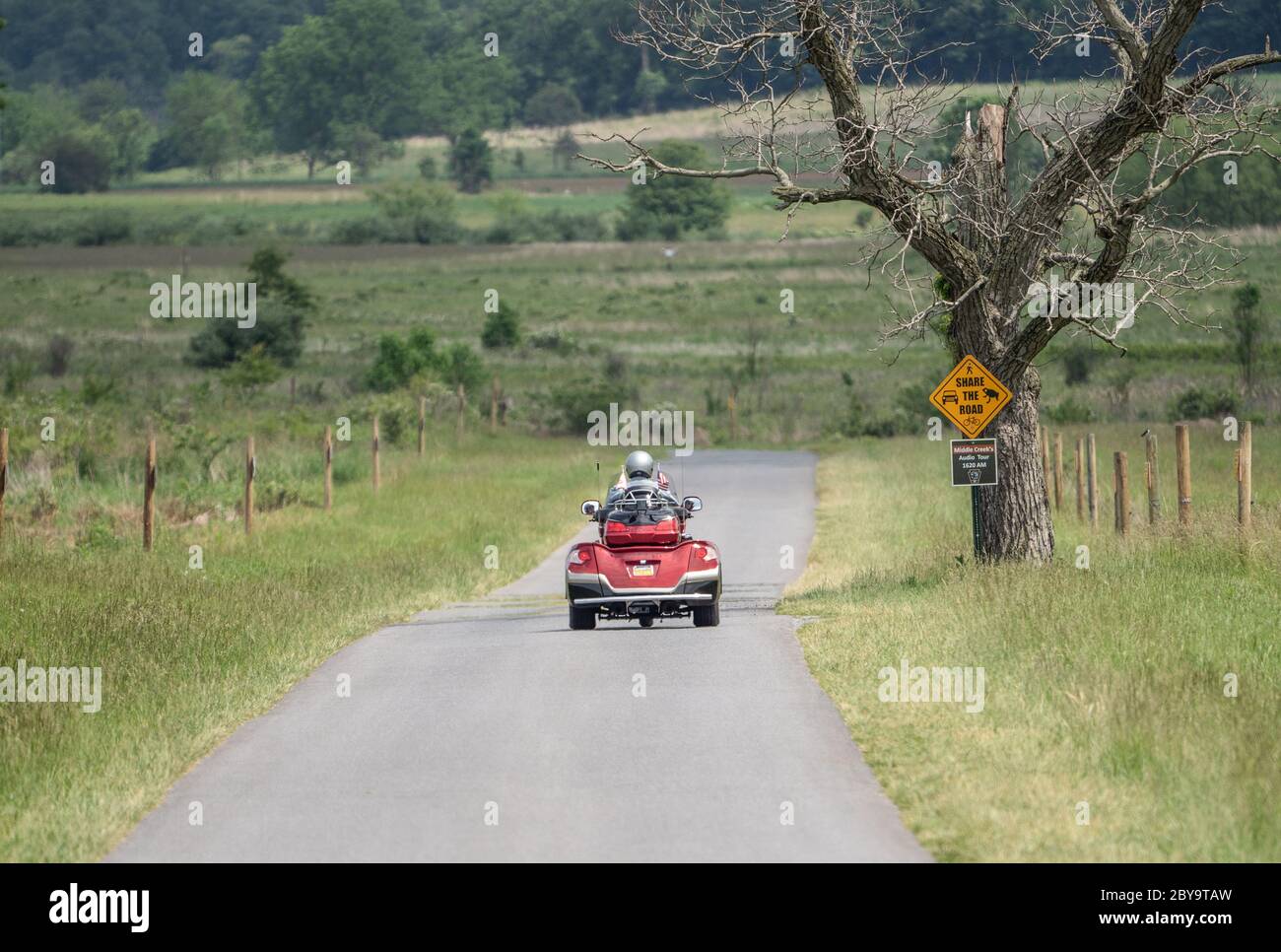 Lancaster County, Pennsylvanie : 4 juin 2020 - homme senior à trois roues sur la route de campagne. Banque D'Images