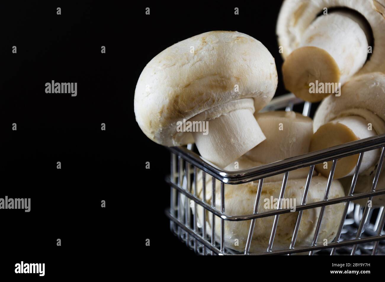 champignons champignés dans un chariot sur fond noir 2 Banque D'Images
