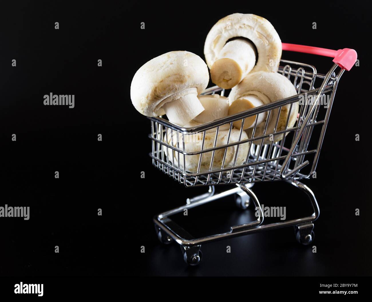 champignons champignés dans un chariot sur fond noir 3 Banque D'Images