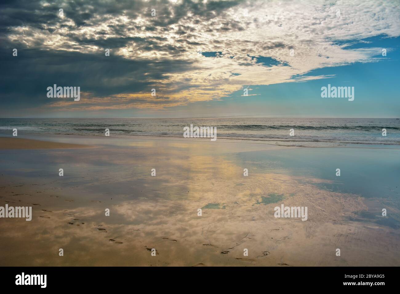 Reflet des nuages sur l'océan, marchant seul sur la plage Banque D'Images