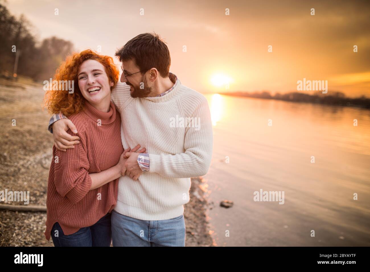 couple qui s'embrasse sur la plage au coucher du soleil Banque D'Images