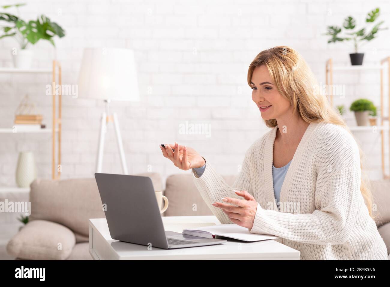 Réunion d'affaires en ligne. Une femme communique avec le client sur un ordinateur portable Banque D'Images