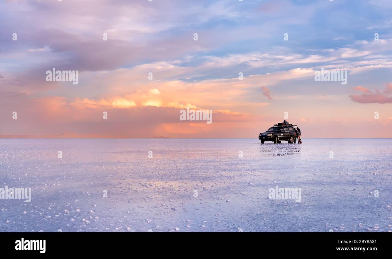 Le groupe touristique est à Salar de Uyuni au coucher du soleil. Au premier plan, le sel grandit dans les eaux peu profondes. Bolivie. Amérique du Sud Banque D'Images