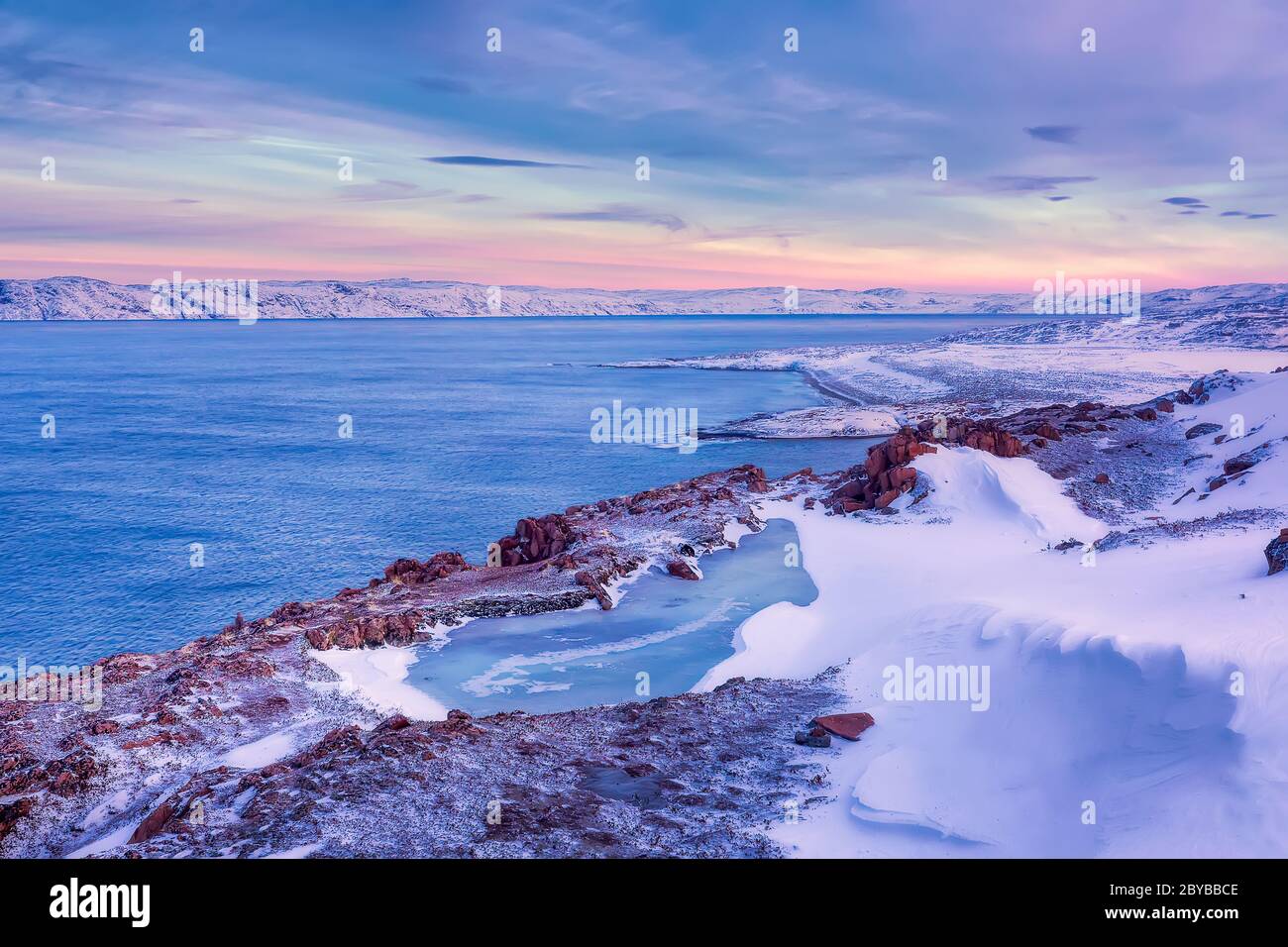 Un lac gelé et la côte de la mer de Barents en hiver au coucher du soleil. Teriberka, région de Mourmansk, péninsule de Kola. Russie Banque D'Images