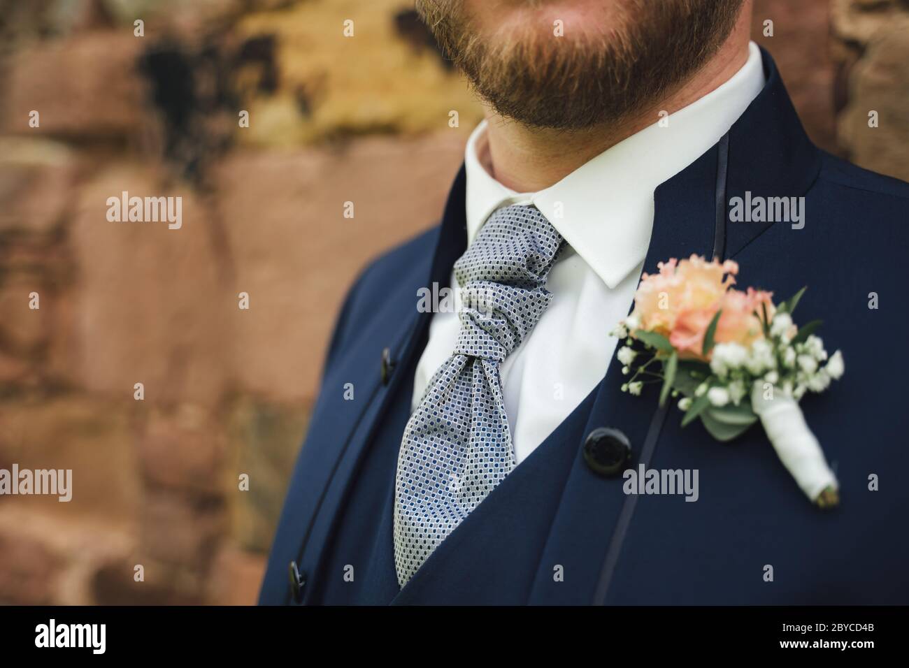 Gros plan du nœud. Marié en costume bleu avec boutonnière de mariage. Faible profondeur de champ. Copier l'espace. Banque D'Images