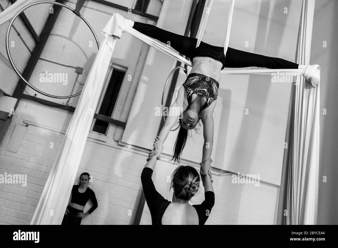 Les danseurs aériens colombiens jouent un duo sur des silks aériens pendant une séance d'entraînement dans une salle de gym à Medellín, Colombie- Banque D'Images