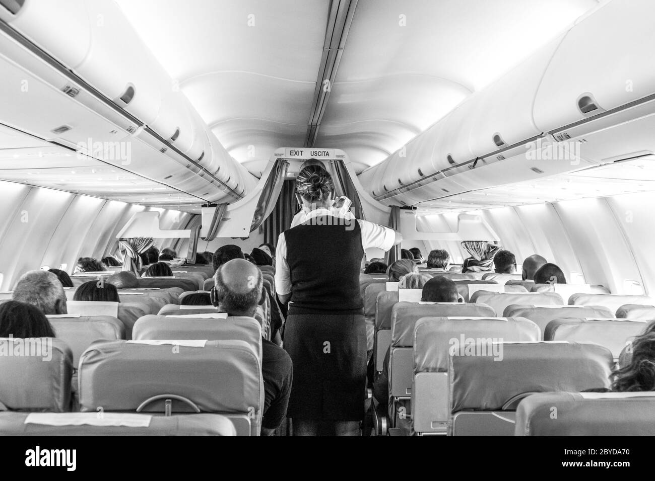 Intérieur de l'avion avec des passagers sur des sièges hôtesse pendant le vol. Banque D'Images