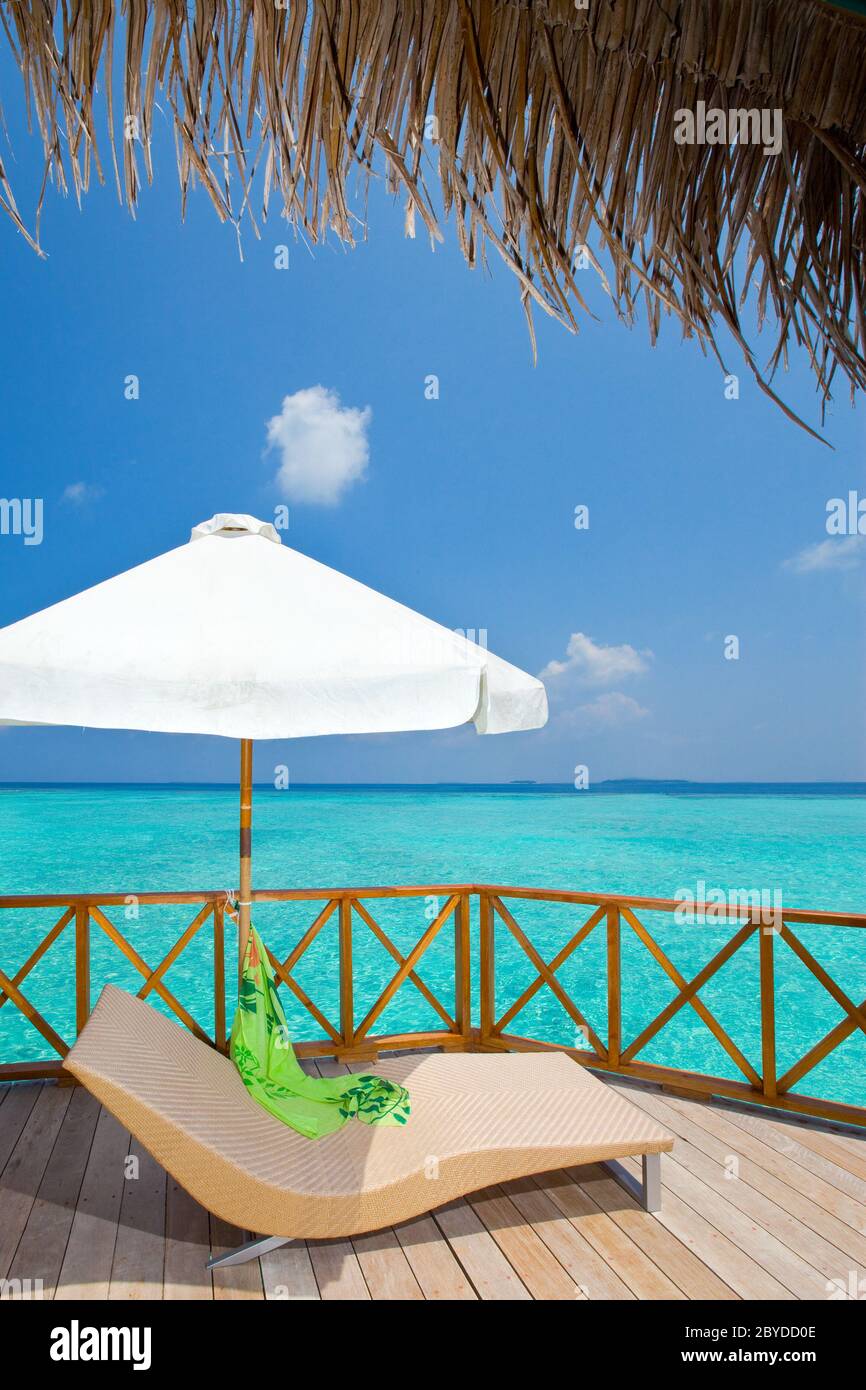 Chaise longue sur une terrasse de villa aquatique, Maldive Banque D'Images