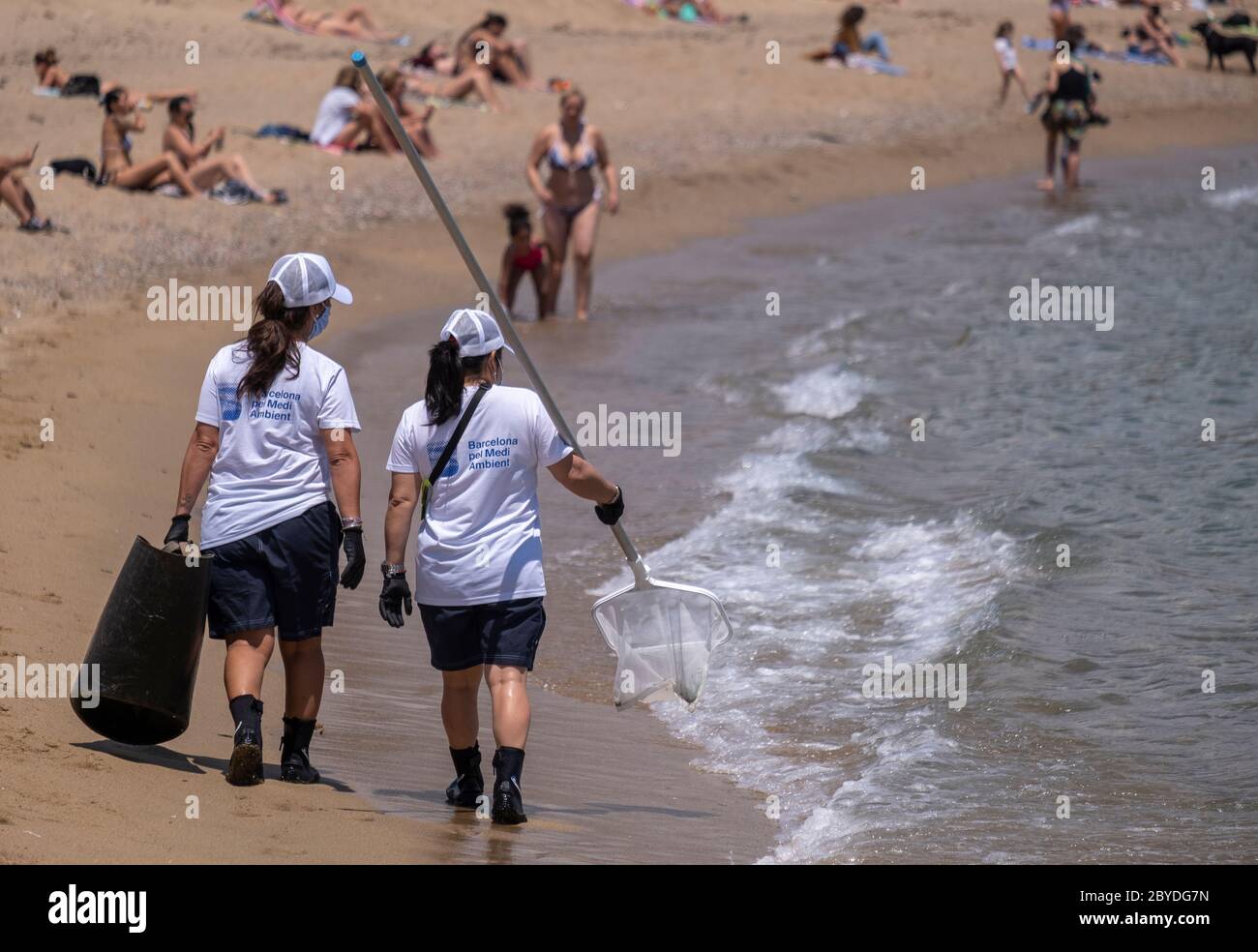 Le personnel de nettoyage de la plage du Conseil municipal de Barcelone est vu se diriger vers les eaux propres de la plage de Barceloneta. Barcelone commence la saison estivale de baignade sur les plages avec de nouvelles mesures pour contrôler la capacité et la distance sociale due à la contagion de Covid-19. Banque D'Images