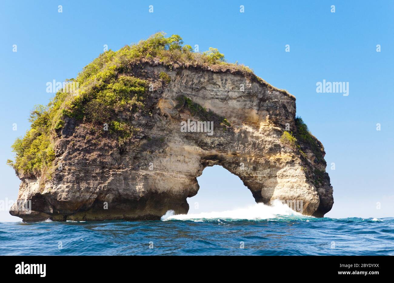 Arche de pierre naturelle - un rocher au bord de l'océan. Indonésie, Banque D'Images