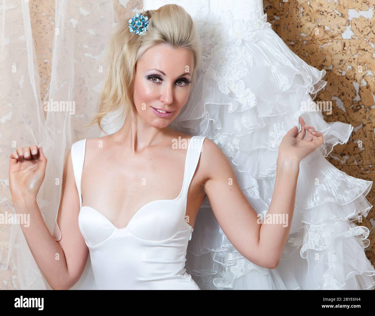 L'heureuse mariée essaie sur une robe de mariage Banque D'Images