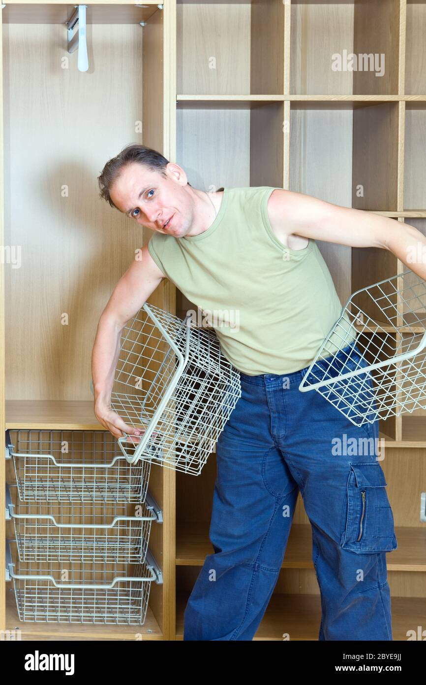 L'homme établit des paniers dans une nouvelle armoire Banque D'Images