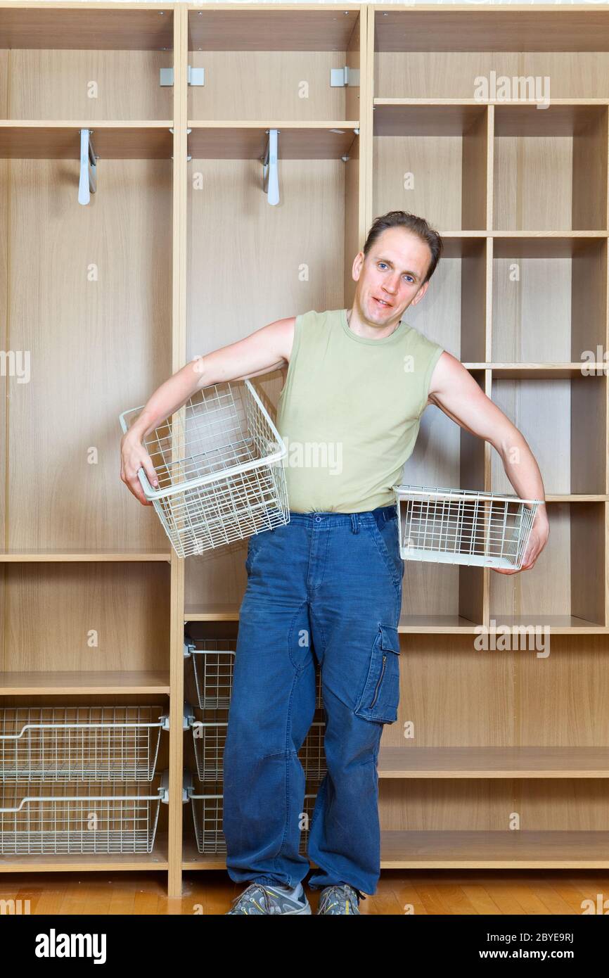 L'homme établit des paniers dans une nouvelle armoire Banque D'Images