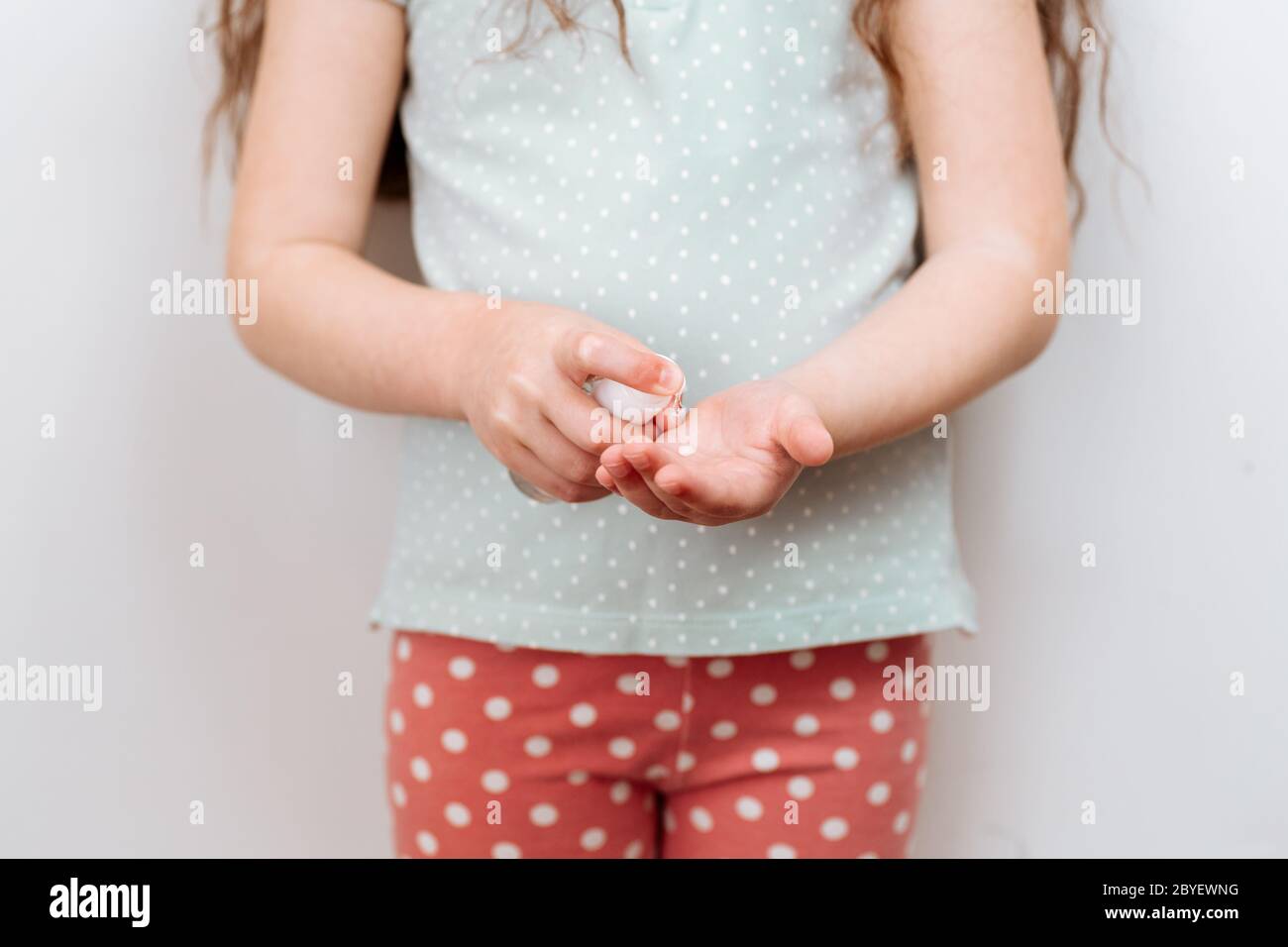 L'enfant utilise un désinfectant pour les mains. Prévention de l'infection et de la dissémination du coronavirus, quarantaine. Banque D'Images