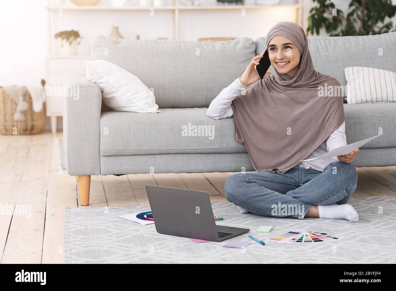 Travail à distance. Femme arabe freelancer utilisant un ordinateur portable et un téléphone portable à la maison Banque D'Images