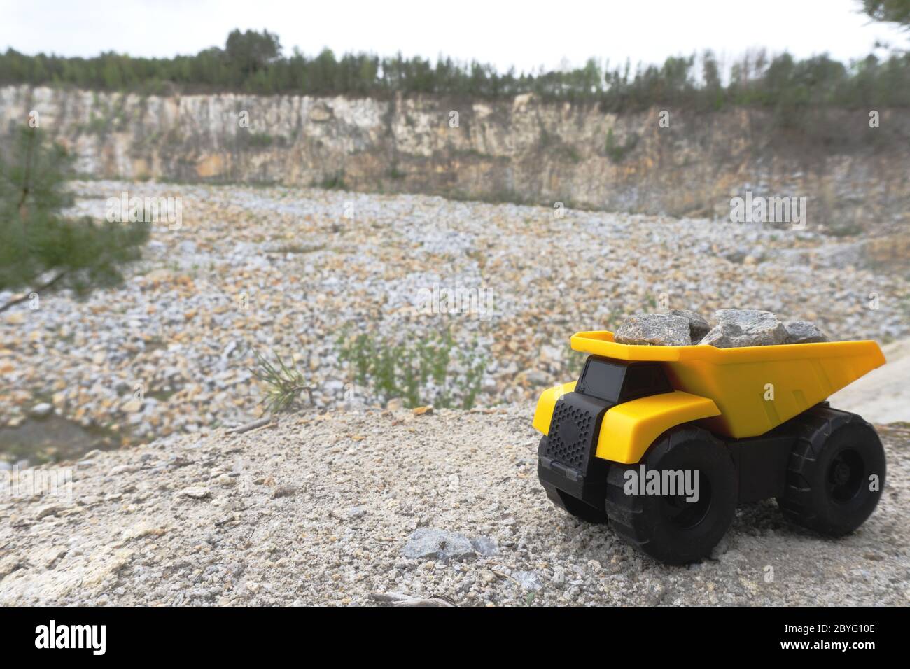 Camion minier jaune avec pierres en haute montagne près de la carrière. Banque D'Images