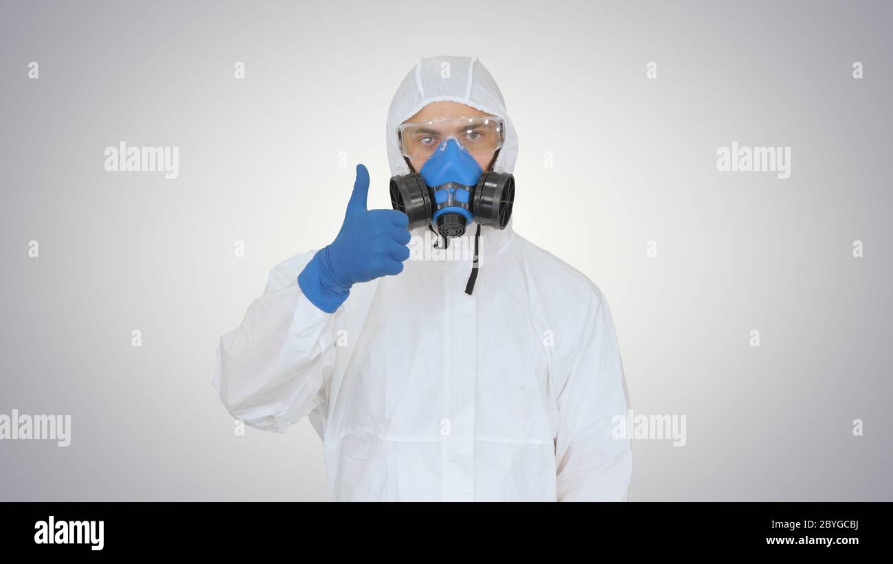 Homme en costume de protection, un masque et un respirateur Thumb sur fond gradient. Banque D'Images