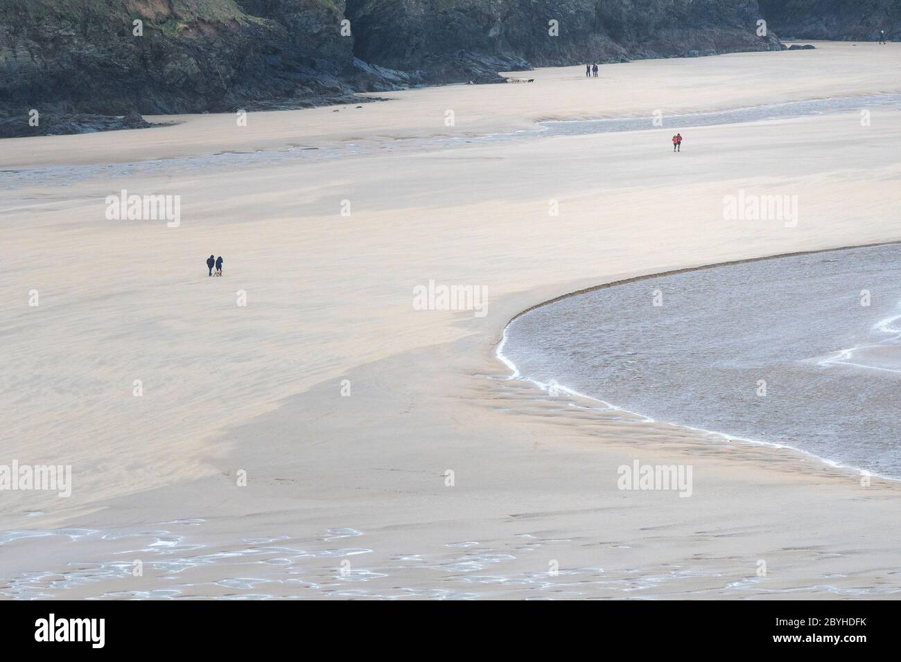 Les personnages éloignés des marcheurs sur la plage primée Crantock à marée basse à Newquay, en Cornouailles. Banque D'Images