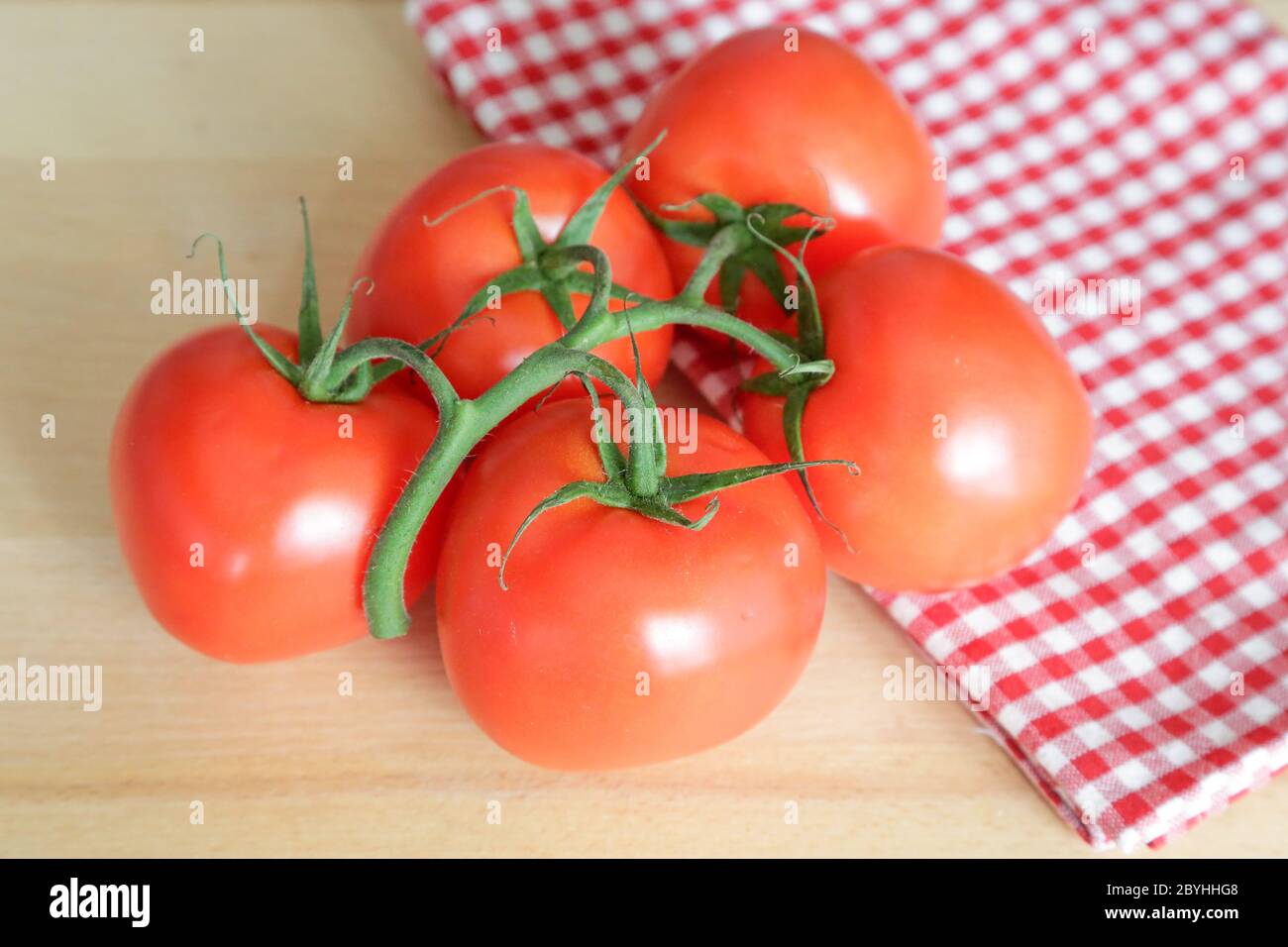 Tomates appelées grappolo sur table en bois, lumière naturelle Banque D'Images