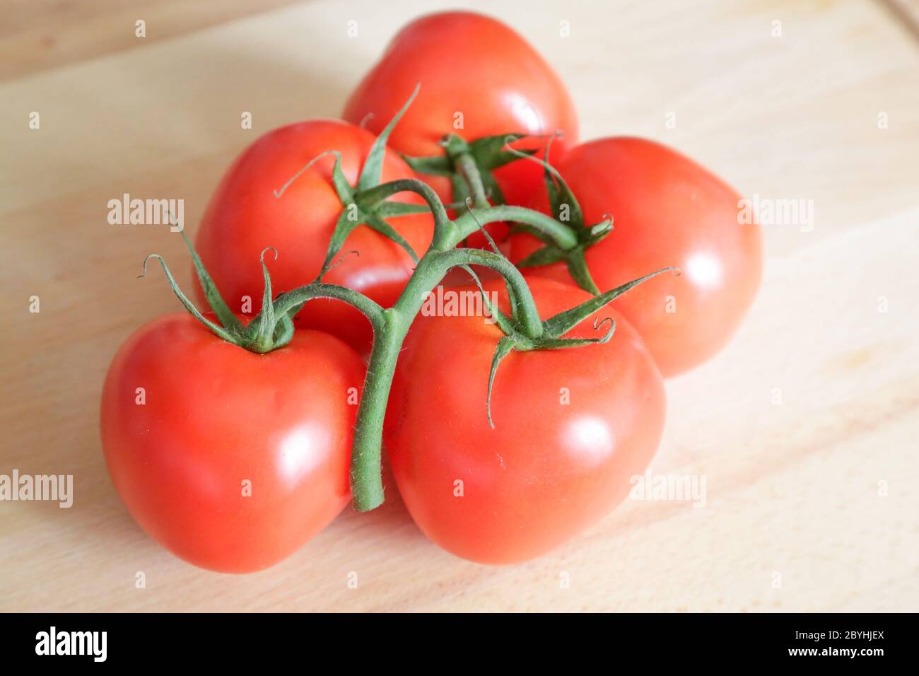 Tomates appelées grappolo sur table en bois, lumière naturelle Banque D'Images