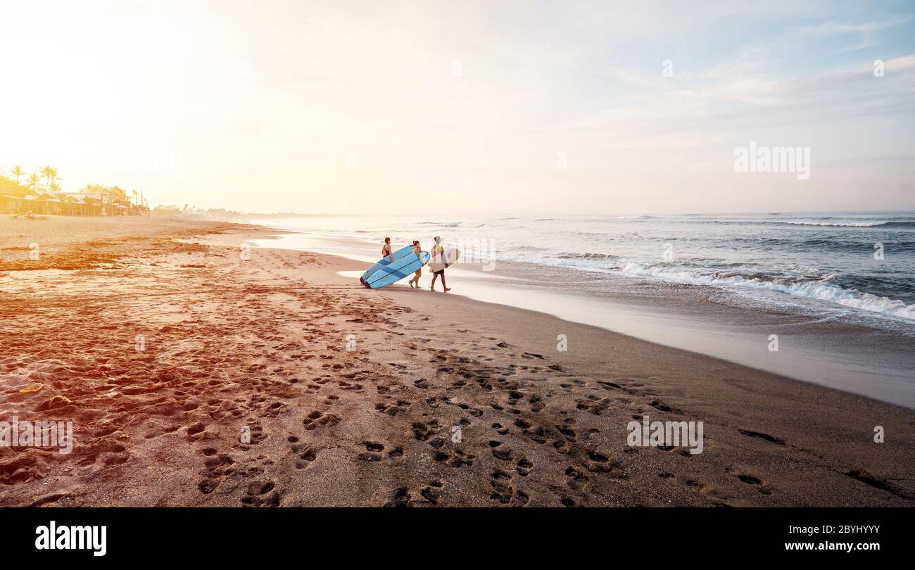 Bali / Indonésie - 17 décembre 2019: Débutants qui vont apprendre à surfer au lever du soleil Banque D'Images