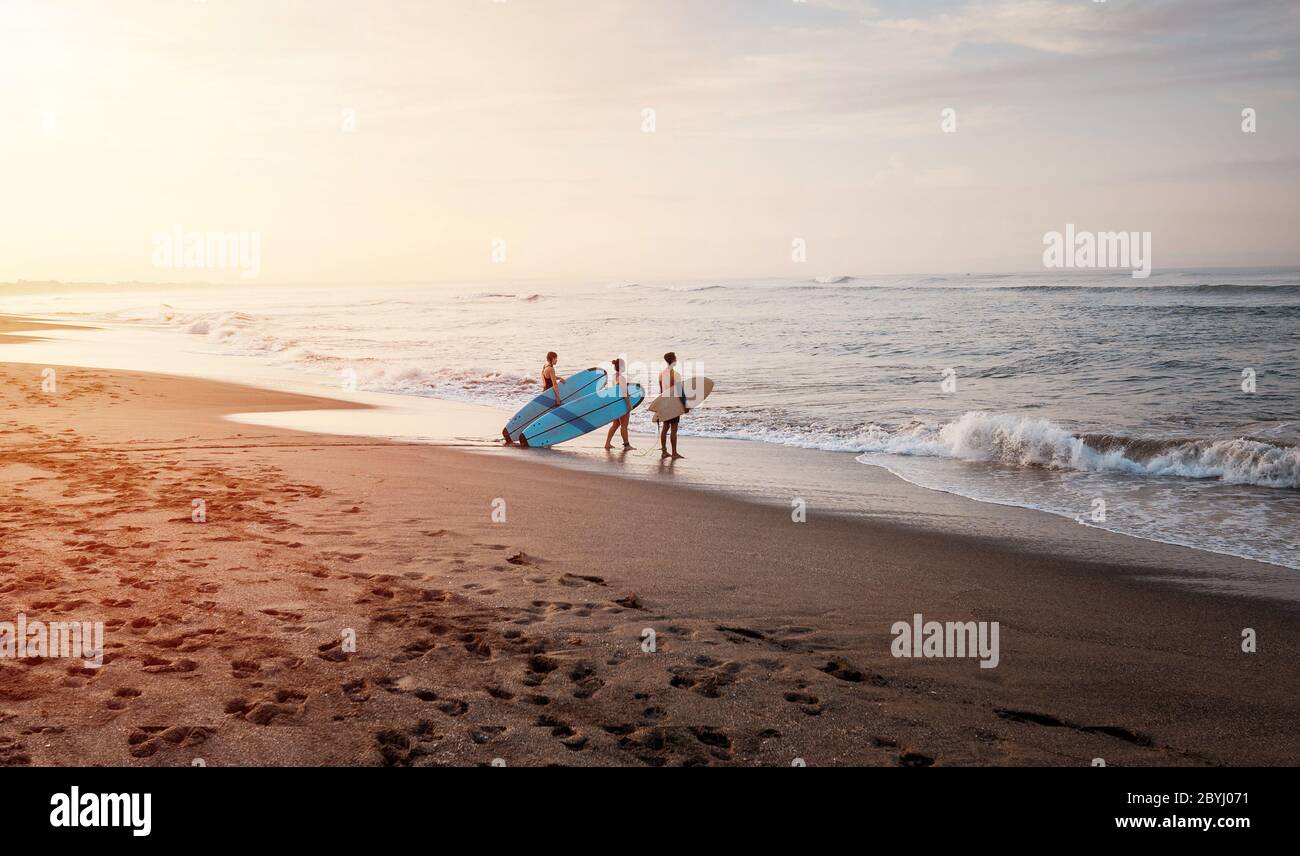 Bali / Indonésie - 17 décembre 2019: Débutants qui vont apprendre à surfer au lever du soleil Banque D'Images