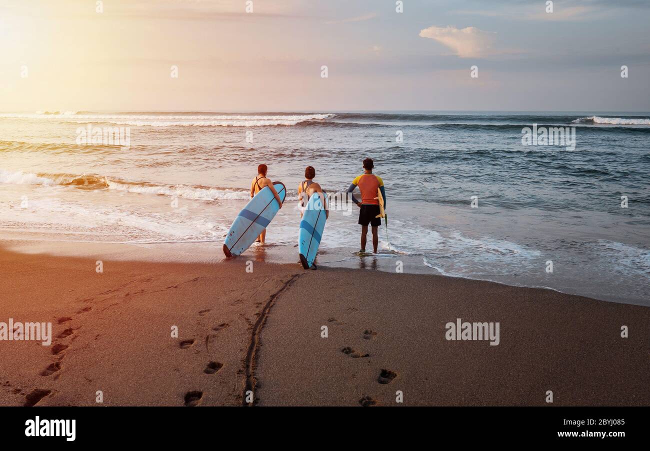 Bali / Indonésie - 17 décembre 2019: Débutants qui vont apprendre à surfer au lever du soleil Banque D'Images