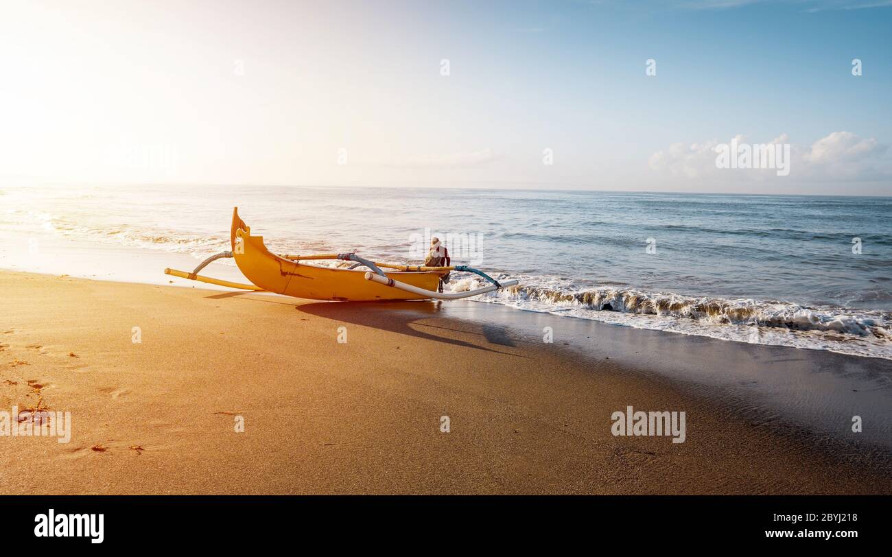 Bateau de pêcheur. Paysage de lever du soleil. Bateau traditionnel balinais jukung. Bateau de pêche à la plage. Réflexion de l'eau. Plage de Sanur, Bali, Indonésie. Banque D'Images