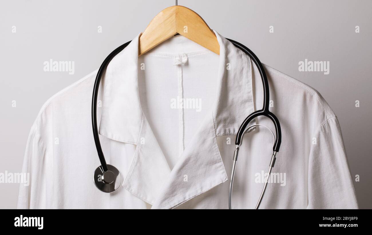 Une vieille blouse médicale et un stéthoscope sur un cintre, gros plan Banque D'Images