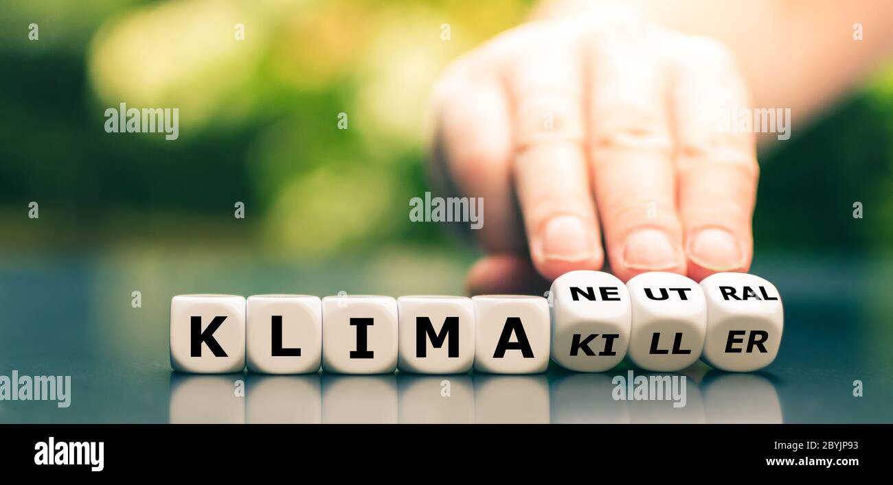 La main tourne les dés et change l'expression allemande 'klima Killer' (' Climate change') en 'klima neutre' ('Climate neutre'). Banque D'Images