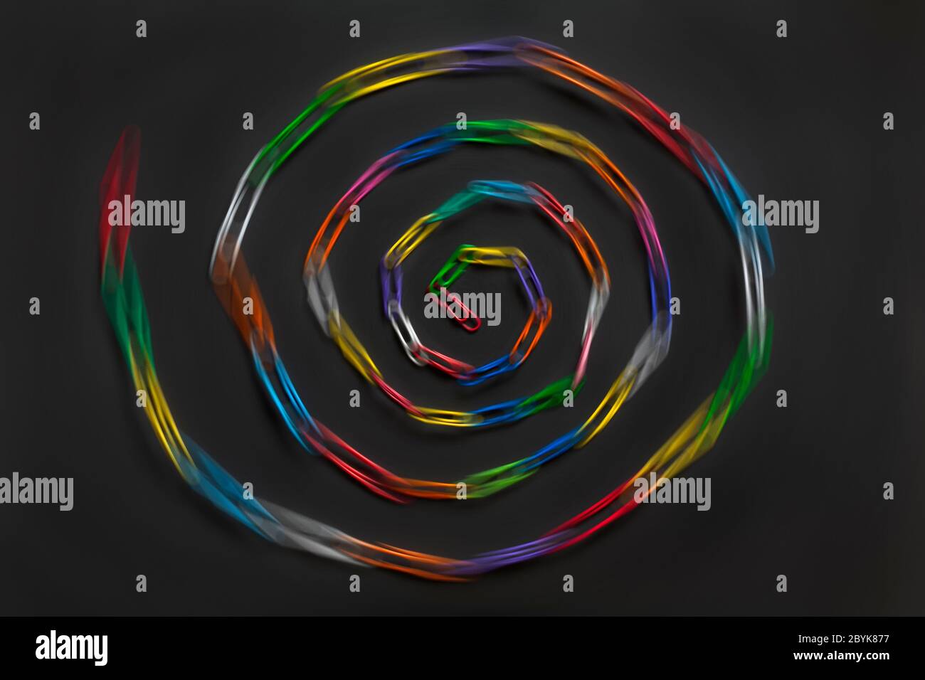 Spirale de chaîne de trombones, spirale de trombones, isolé sur fond noir - trombones, trombones abstraits flou flou Banque D'Images