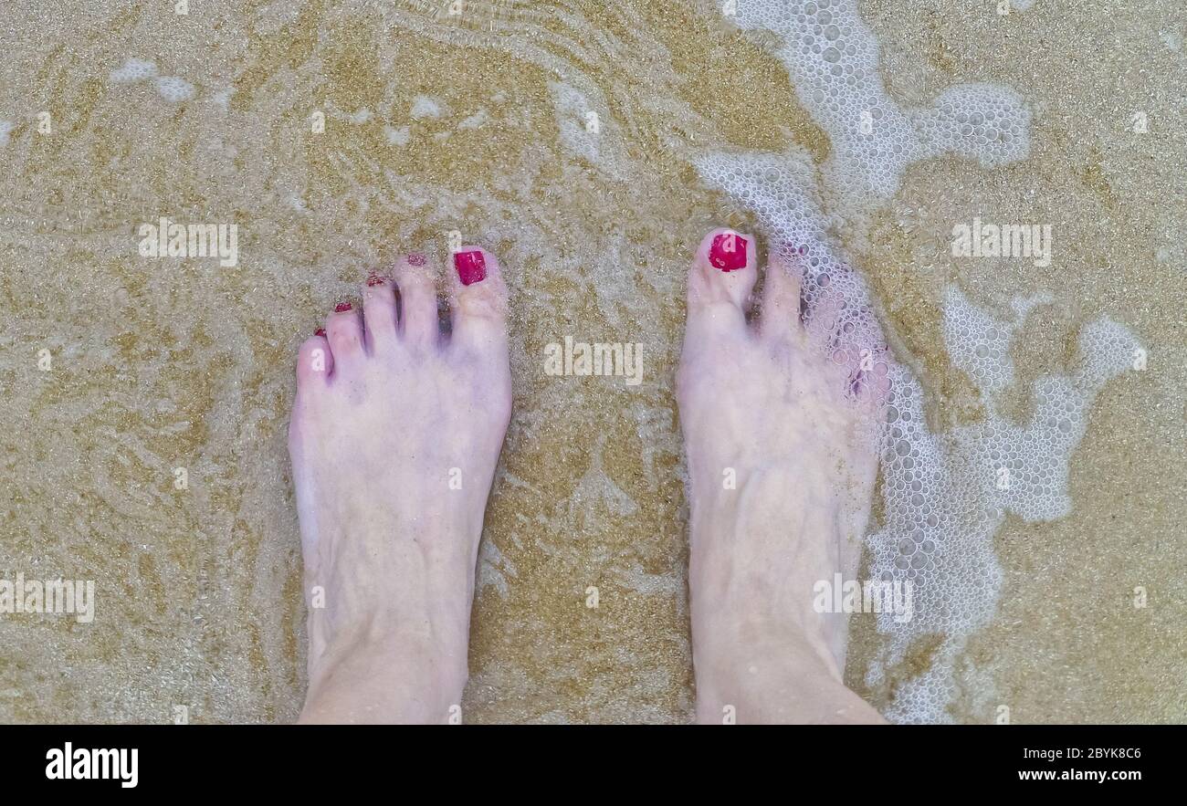 Gros plan des pieds de femme avec vernis à ongles rouges dans t Banque D'Images