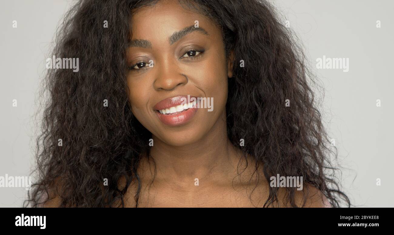 Belle femme afro-américaine souriante pour l'appareil photo Banque D'Images