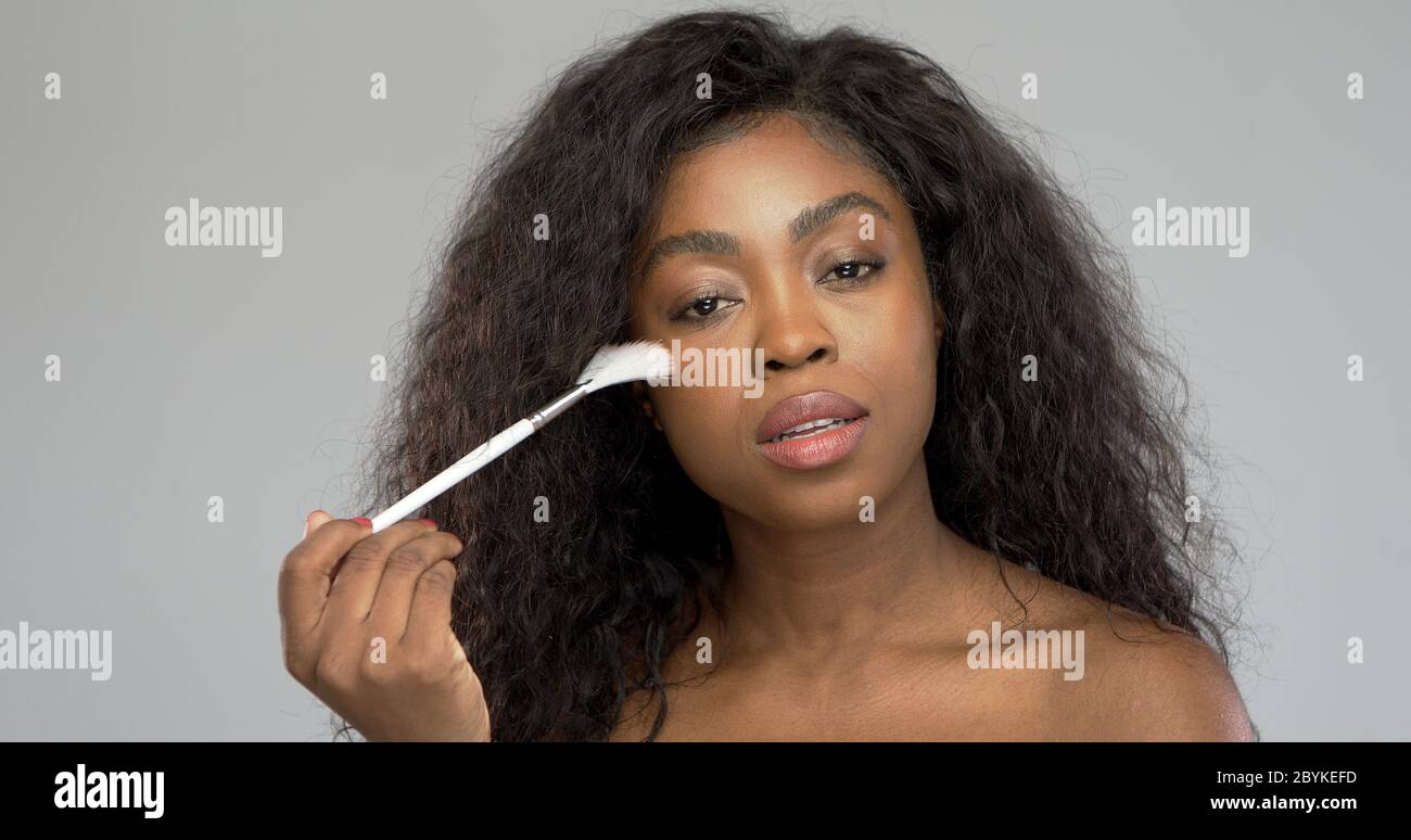 African American Woman applying makeup Banque D'Images
